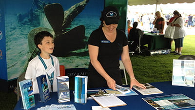 A child and an adult providing information at booth