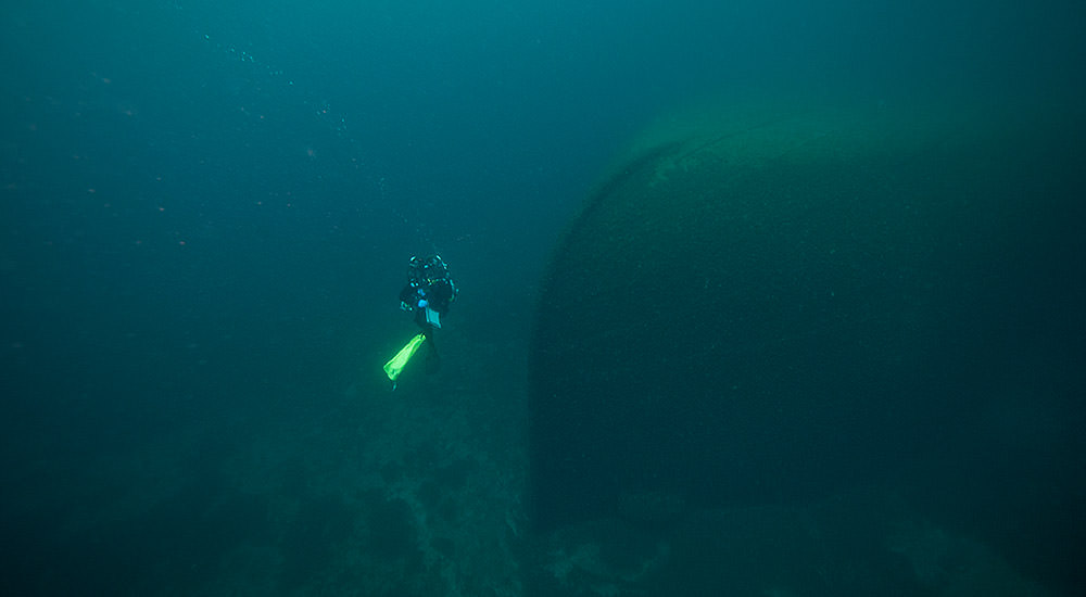 A diver hovers near the bow of the D.R. Hanna