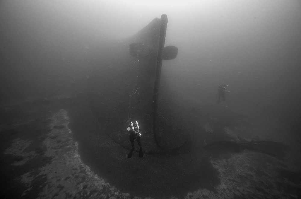 scuba divers explore the stern of D.R. Hanna