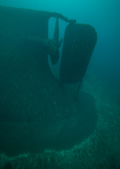 diver swimming by the stern and propeller
