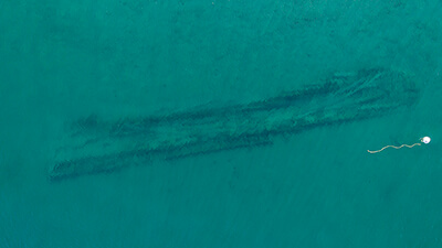an aerial view of a shipwreck and buoy
