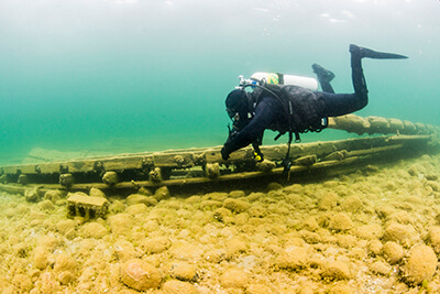 a diver inspects debris from shipwreck