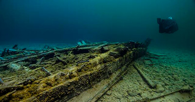 A diver swims along side a shipwreck