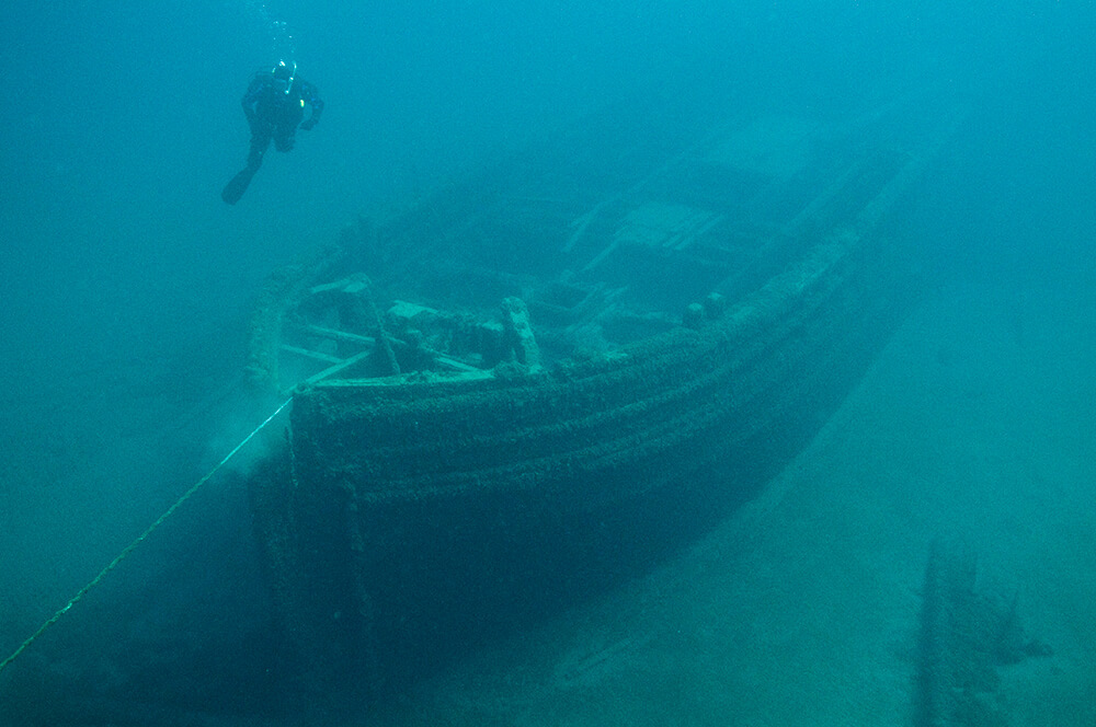  scuba diver hovers over the bow of E.B. Allen