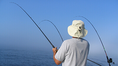 A man fishing from a boat in open water
