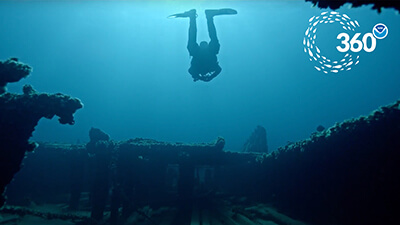 A diver swims over a shipwreck