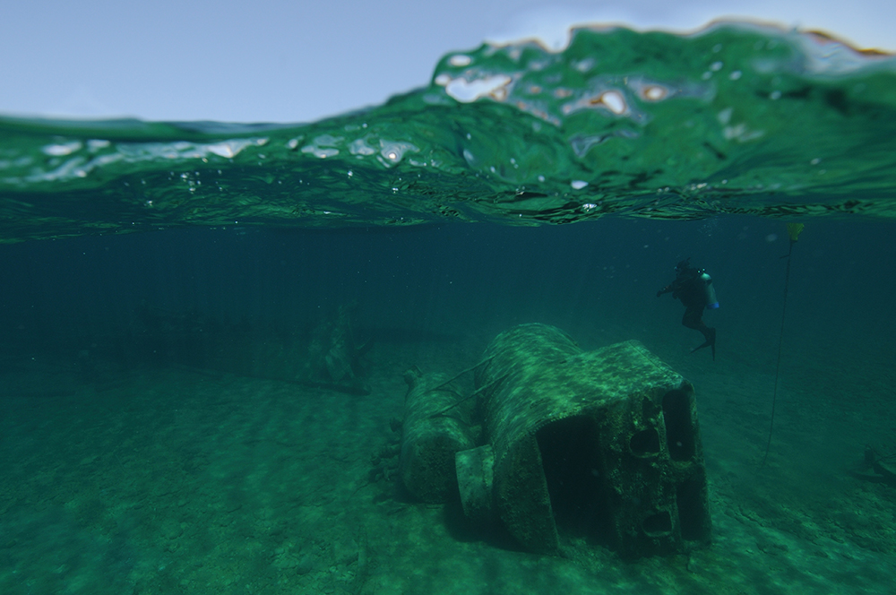 a shipwreck rests on its side just below the surface