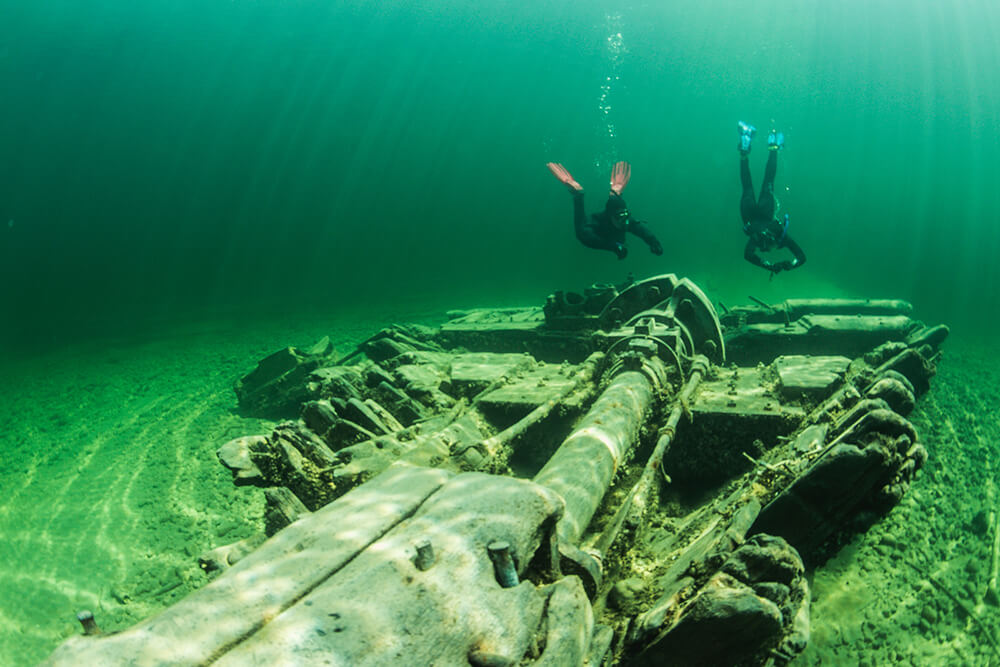 Two snorkelers swim above a shipwreck