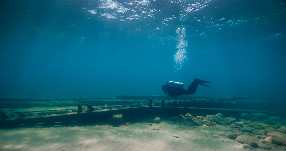 A diver swims above a shipwreck