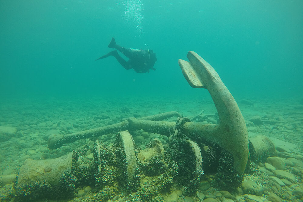 A diver swims above an anchor
